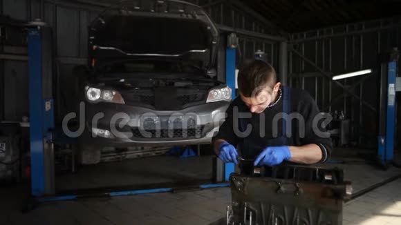 男机修工为汽车收集一台重建的马达视频的预览图
