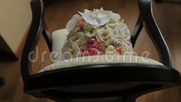 白色和粉红色玫瑰的美丽婚礼花束躺在古董古董椅子上视频的预览图