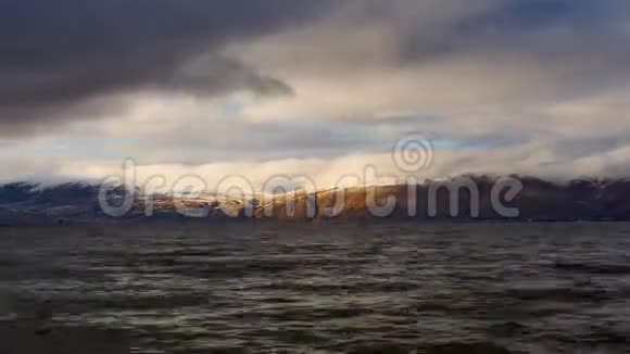 白天白云在背景山的塞万湖上移动的时间推移视频的预览图