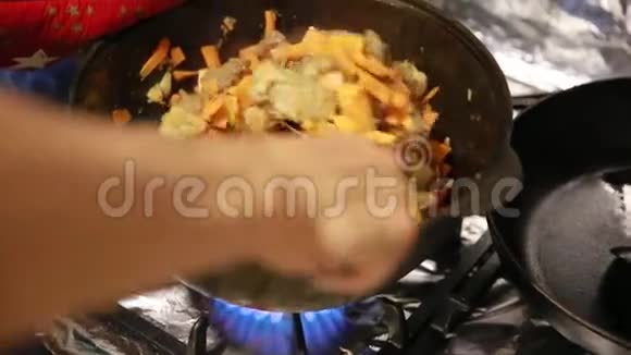 开始煮皮拉夫谢夫在铸铁水壶里用胡萝卜搅动肉视频的预览图