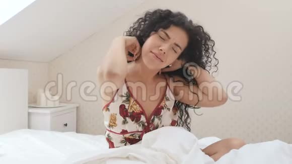漂亮的卷发女士躺在床上视频的预览图