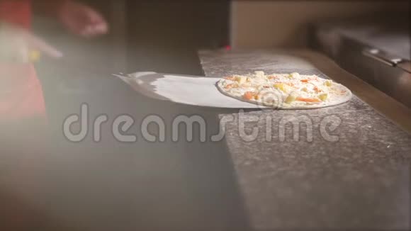 厨师把比萨饼放在铲子上把比萨饼放进烤箱4K视频的预览图