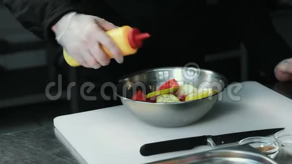 厨师长把油和酱油从瓶子里倒在蔬菜上放在白色的切割板上视频的预览图