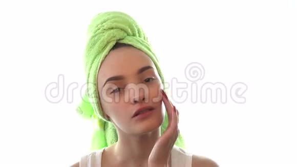 可爱的女孩头发上有毛巾打在面霜上视频的预览图