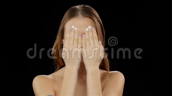 女孩用手遮住她的脸然后用牙套露出他的微笑黑色的慢动作视频的预览图