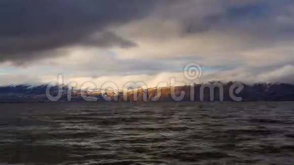 在背景山的塞万湖上移动的云的白天时间推移视频的预览图