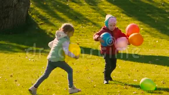 小女孩拿着气球在踢另一个绿色气球视频的预览图
