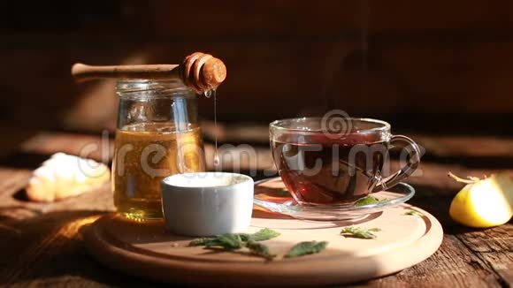 特写是真正的蜂蜜从勺子里慢慢排出早上好茶道一杯茶的特写视频的预览图