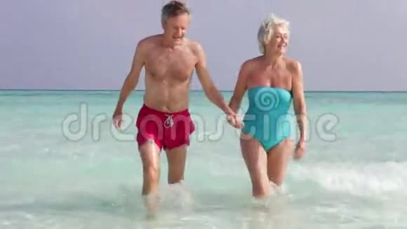 高级夫妇走出热带海洋视频的预览图