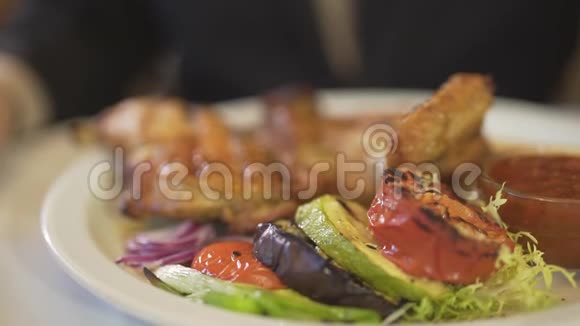 在高级餐厅用叉子刀切美味的烧烤蔬菜炸鸡肉餐近距离观看男人的手视频的预览图