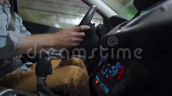 男子驾驶汽车通过停车场并正在寻找一个地方停车或开车离开侧视图视频的预览图