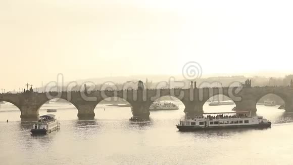 布拉格查尔斯桥上的游客在日落时乘坐旅游船的背景下总体计划视频的预览图