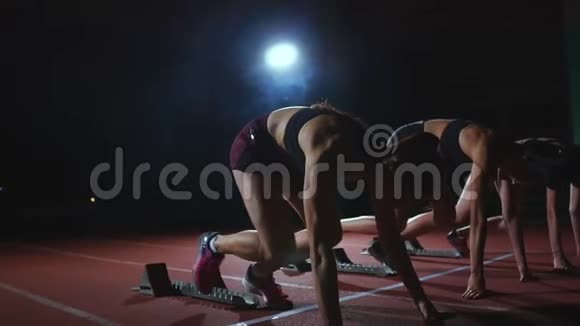 女运动员在赛跑前在跑道上热身在慢动作中视频的预览图