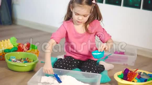 一个可爱的小女孩在家玩动能沙视频的预览图