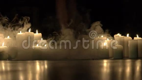 女孩的腿在黑暗中燃烧着蜡烛的浓烟中行走慢慢地视频的预览图