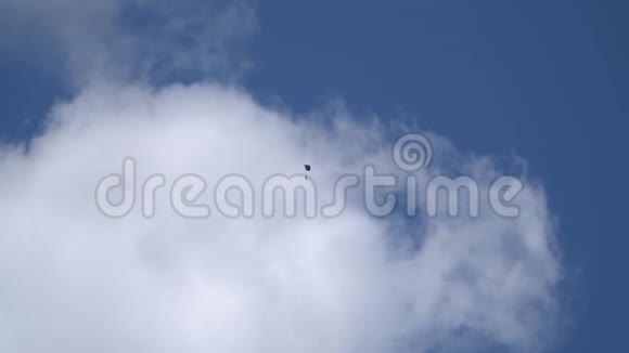 一个带蓝色降落伞的伞兵在云层的背景下盘旋在天空从下面可以看到视频的预览图