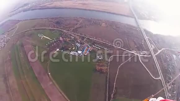 跳伞员跳伞在多云的天空中绿色的田野河流身高景观视频的预览图