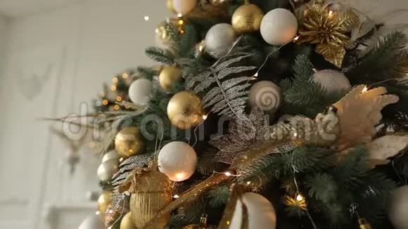 时尚的白色内部与冷杉圣诞树花环充满金色装饰玩具灯和花环视频的预览图