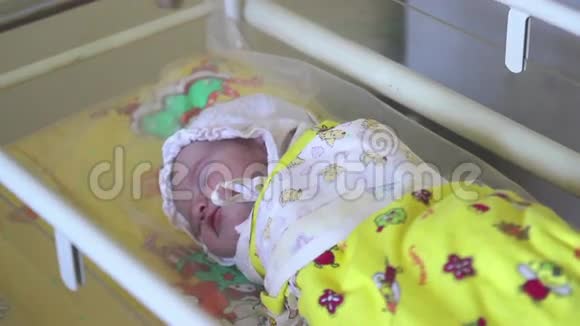 一个新生儿正睡在医院的儿童床上视频的预览图