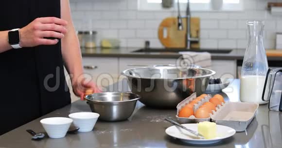 女人在厨房的碗里打鸡蛋视频的预览图