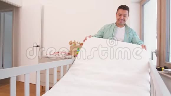父亲在家里安排婴儿床和床垫视频的预览图
