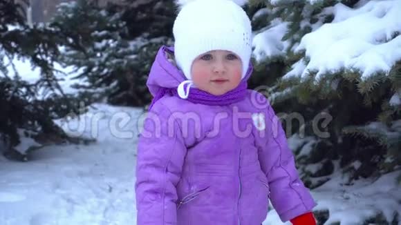 冬天小女孩站在圣诞树附近的街道上视频的预览图