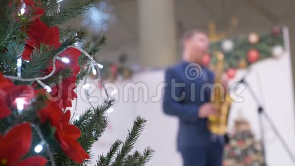 圣诞树装饰在购物中心在背景中音乐家演奏萨克斯管背景视频的预览图