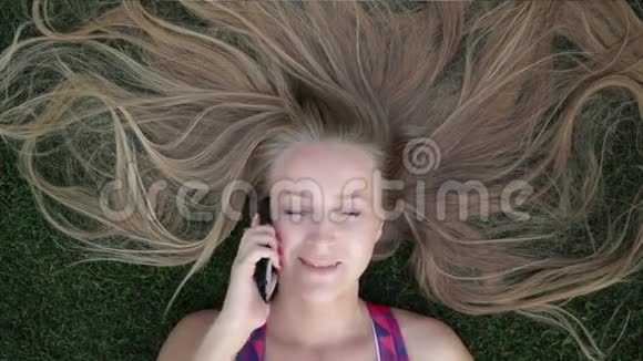 一个金发美女躺在草地上视频的预览图