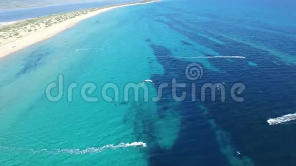 令人叹为观止的4k无人驾驶飞机空中全景人们在晴朗的蓝色绿松石海水中在大风的夏日风筝冲浪视频的预览图