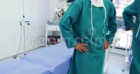 手术室男性外科医生双手叉腰站立的画像视频的预览图