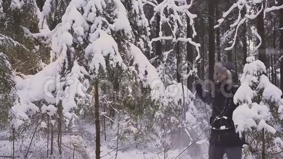快乐的疯子在冬天的森林里跳舞摇树视频的预览图
