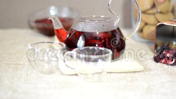 早餐红茶酿造工艺餐桌茶壶中红茶茶叶木槿和两个玻璃杯视频的预览图