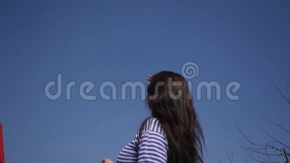 年轻的女孩正看着飞机在蓝天上飞行慢动作1920x1080高清高清视频的预览图