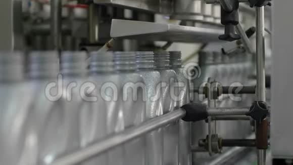 自动工业设备一排灰色塑料瓶在移动输送线上的工厂视频的预览图