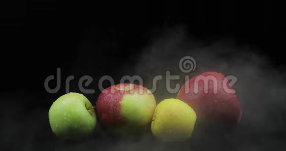 冷冰中的热带水果苹果黑色背景下的雾烟视频的预览图