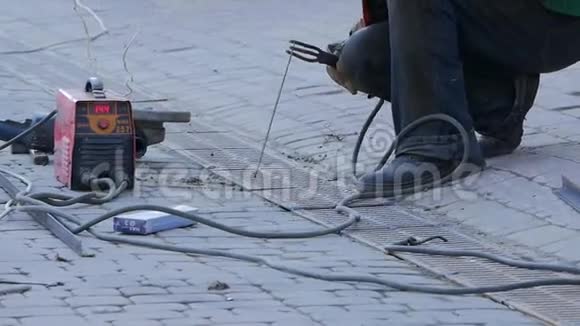 有人脸保护焊接金属零件焊工在街上工作视频的预览图
