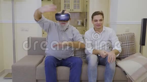 祖父带着孙子在家测试虚拟现实眼镜视频的预览图