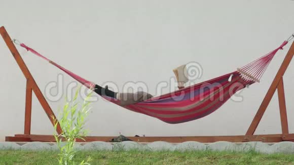 放松的男人在吊床上看书视频的预览图