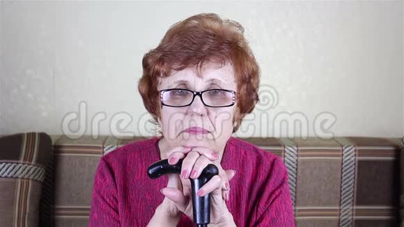 一位戴眼镜的老年妇女的肖像她靠在拐杖上视频的预览图