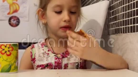 可爱的小女孩正在吃早餐孩子吃饼干喝茶视频的预览图