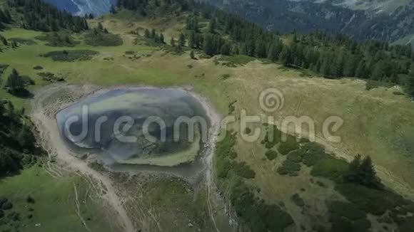 在阳光明媚的夏天在蓝色的高山湖上空盘旋露出山林山谷欧洲阿尔卑斯山视频的预览图
