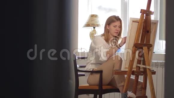 坐在椅子上画画的女人视频的预览图