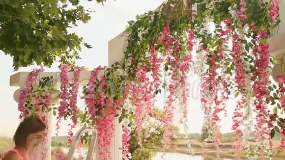 女孩花店用鲜花装饰婚礼拱门视频的预览图