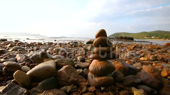 4K岩石叠加平衡和和谐的海滩与傍晚的环境光和声音视频的预览图