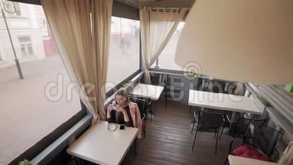 美丽的女孩喝咖啡在咖啡馆放松喝咖啡的女人视频的预览图