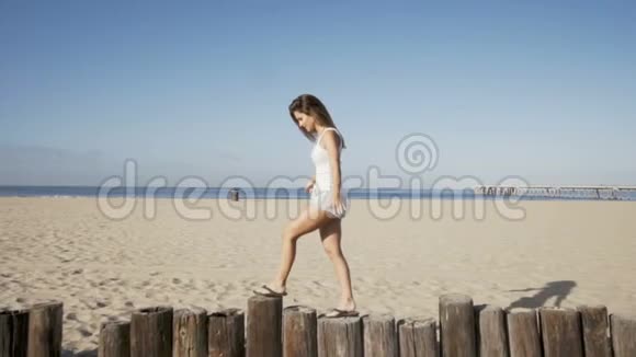快乐的年轻女子平衡木柱夏天的感觉视频的预览图