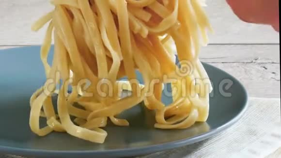 用钳子煮意大利面烹饪意大利面的概念女性手在盘子里放意大利面视频的预览图
