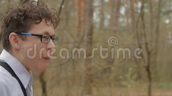 戴眼镜的家伙在森林里吃三明治视频的预览图