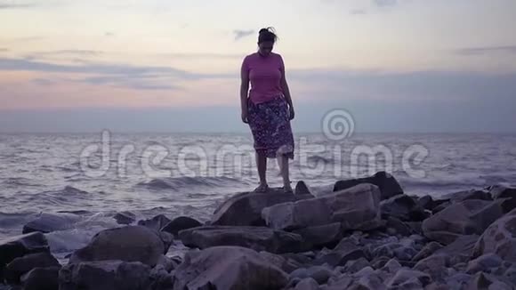 一个女孩正沿着海边的海滩散步高清1920x1080慢动作视频的预览图
