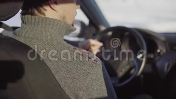 年轻人在冬天的路上开车从后面看视频的预览图